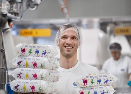 Midor Mitarbeiter hält Fasnachtschüechli Collaboratore Midor con confezioni di frittelle di carnevale
